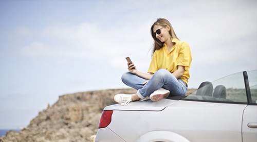 Girl taking a selfie on top of her car